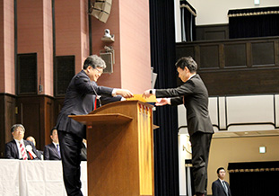 萩生田文部科学大臣より<br />表彰状を授与される時松校長（右）