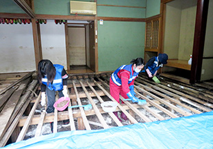 民家の床下の泥出し作業を行う学生<br />(7月26日天瀬町)