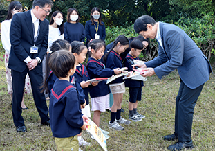 お礼のプレゼントを手渡す北野学長