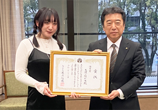賞状を掲げる池田さん(左)と足立市長