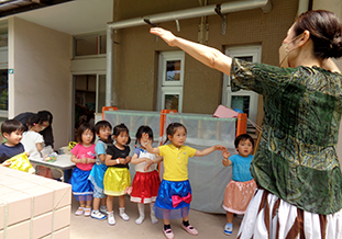 祖父母にフラダンスを習う園児たち